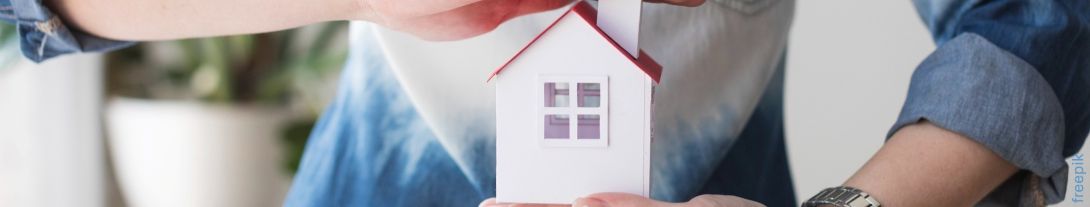Hände halten Hausmodell